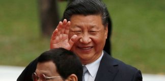 Chinese President Xi Jinping waves to the media as he walks with Philippine President Rodrigo Duterte before their one on one meeting at the Malacanang presidential palace in Manila, Philippines, November 20, 2018.