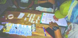 An antidrug personnel examines the suspected shabu and drug paraphernalia seized from Andre Mabasa after he sold illegal drugs to a poseur-buyer in Kalibo, Aklan on June 27. PDEA REGION 6