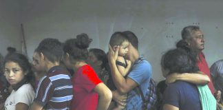 Detained migrants stand together in a storage room at the back of the Azteca Hotel where they tried to hide from Mexican immigration agents conducting a raid in Veracruz, Mexico, Thursday, June 27, 2019. Under increasing US pressure to reduce the flow of hundreds of thousands of Central Americans through Mexican territory, Mexico's government has stepped up enforcement. AP