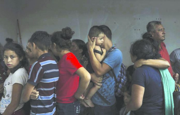 Detained migrants stand together in a storage room at the back of the Azteca Hotel where they tried to hide from Mexican immigration agents conducting a raid in Veracruz, Mexico, Thursday, June 27, 2019. Under increasing US pressure to reduce the flow of hundreds of thousands of Central Americans through Mexican territory, Mexico's government has stepped up enforcement. AP