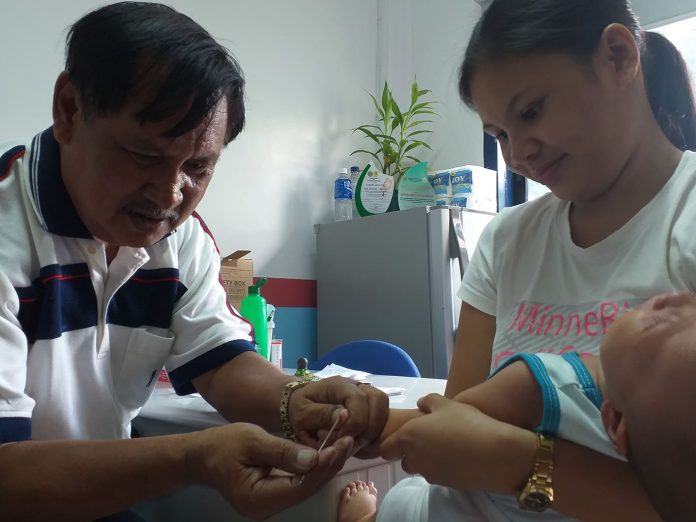 DENGUE TEST. Volunteer medical technologist Buenaventura Mainar Jr. extracts a blood specimen from a baby at the rural health unit of Cabatuan, Iloilo. The mother wants to find out if her baby has dengue. Cabatuan has 256 dengue cases with one death, data from the Provincial Health Office of Iloilo show. The province is under a state of calamity due to a dengue outbreak. IME SORNITO/PN