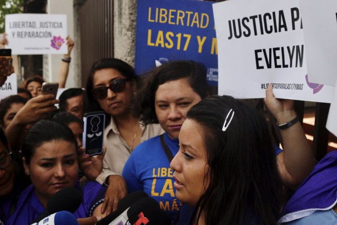 Evelyn Beatriz Hernandez, front, walks past protestors supporting her as she arrives at court in San Salvador, El Salvador, Monday, July 15, 2019. The young woman who birthed a baby into a toilet in faces a second trial for murder after having already served 33 months. AP