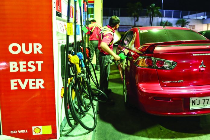 A gas station attendant in Metro Manila refuels a private vehicle. RAPPLER