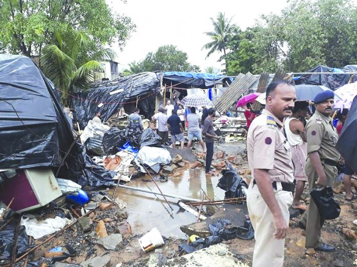 Rescuers and onlookers stand at the spot of a wall collapse in Mumbai, India, Tuesday, July 2, 2019. Nearly a dozen people are feared killed. Building collapses are common in India during the June-September monsoon season, when heavy rains weaken the foundations of structures that are poorly constructed. AP