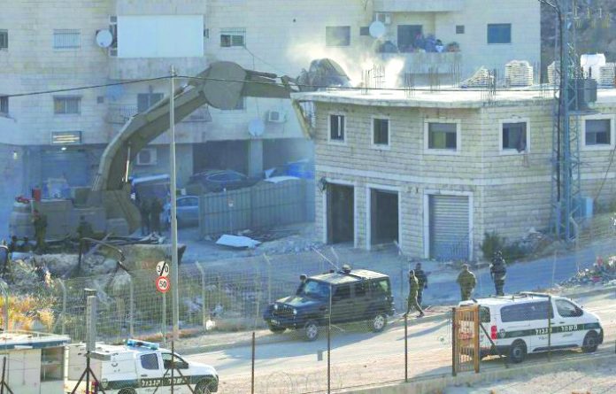 An Israeli machinery demolishes a Palestinian building in the village of Sur Baher which sits on either side of the Israeli barrier in East Jerusalem and the Israeli-occupied West Bank July 22, 2019. REUTERS