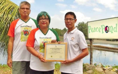 Negrense organic farmer Jesus Antonio Orbida (left) with his wife Checcs – founders of the PeacePond in Binalbagan, Negros Occidental – receive a certificate of accreditation issued by the Department of Tourism-Western Visayas. PNA