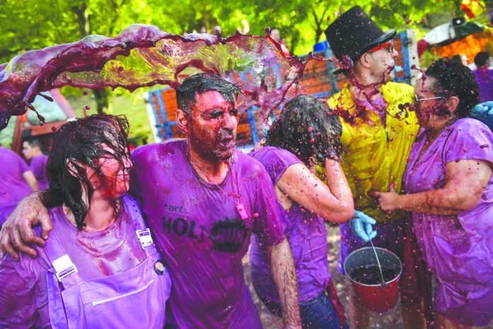 People take part in a wine battle, in the small village of Haro, northern Spain, Saturday, June 29, 2019. Hundreds of revelers participate in this famous summer battle throwing thousands of liters of red wine over each other. AP