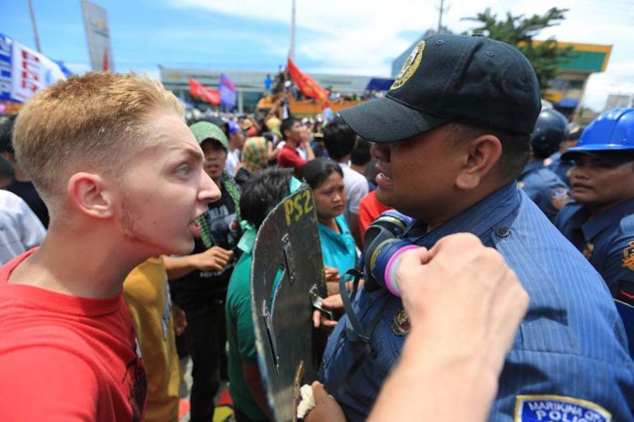 Dutch activist Thomas van Beersum confronts Filipino police officer Joselito Sevilla, who broke into tears amid a dispersal of protesters outside Batasang Pambansa during the State of the Nation Address in 2013. The foreigner was later deported. ABS-CBN NEWS