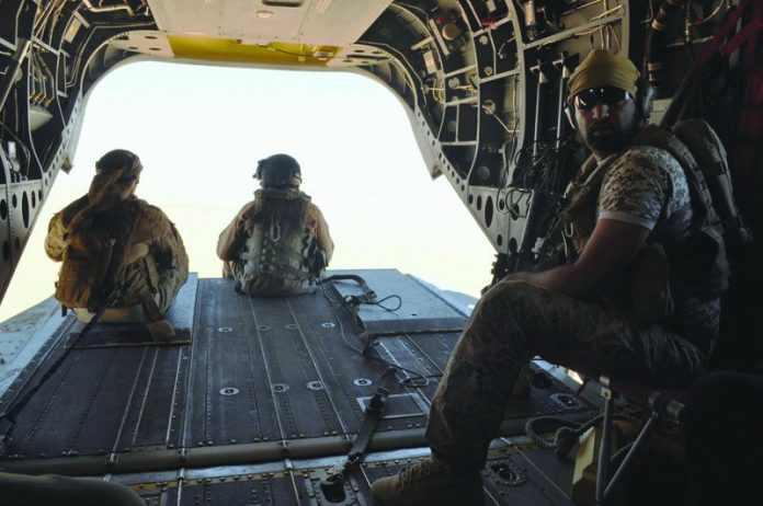 Emirati soldiers stand guard out the rear gate of a Chinook military helicopter traveling from Saudi Arabia to Yemen in this Sept. 14, 2015 file photo. AP