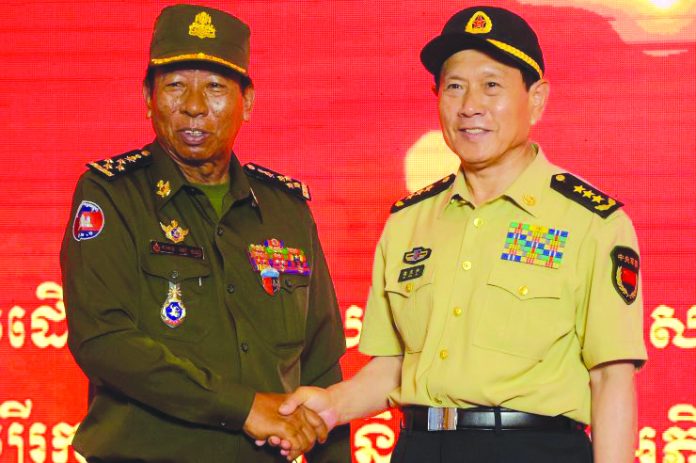 China’s Defence Minister Wei Fenghe (right) shakes hands with Cambodia's Defence Minister Tea Banh during a visit to a military exhibition in Phnom Penh on June 19, 2018. CNBC