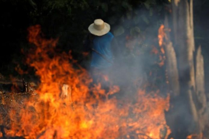 A man works in a burning tract of Amazon jungle as it is being cleared by loggers and farmers in Iranduba, Amazonas state, Brazil, August 20, 2019. Reuters