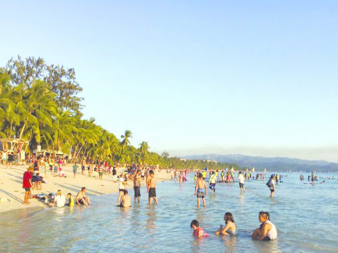 Tourists enjoy the world-famous white sand beach of Boracay Island in Malay, Aklan. In July this year, international website, Travel, included the famed-island resort in the top three most crowded destinations in the world. BOY RYAN ZABAL/AKEAN FORUM