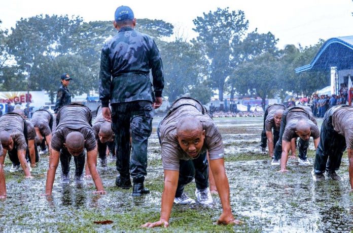 WHEN THE GOING GETS WE AND MUDDY. New police recruits get ready for their pushups during reception rites at the wet and muddy grounds of Camp Delgado, the headquarters of the Police Regional Office 6 in Iloilo City. Four hundred all-male police recruits took oath as members of the Philippine National Police yesterday, Aug. 28, 2019. IAN PAUL CORDERO/PN