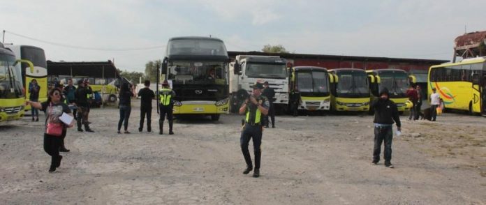 Policemen secure Ceres buses at the Dynamic Builders compound in Barangay Alijis, Bacolod City. ARCHIE REY ALIPALO/PN