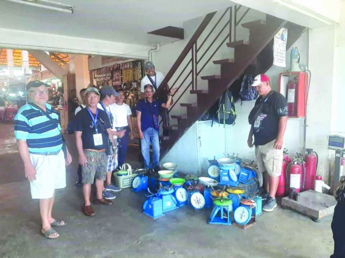 Personnel of Roxas City Environmental Sanitation and Enforcement Team seize at least 22 defective weighing scales from vendors at the Teodoro Arcenas Trade Center during a surprise inspection on Aug. 21. GLENN BEUP/PN