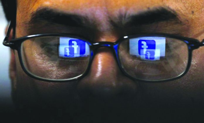 Facebook logo is reflected in glasses in this picture illustration taken April 1, 2019. REUTERS