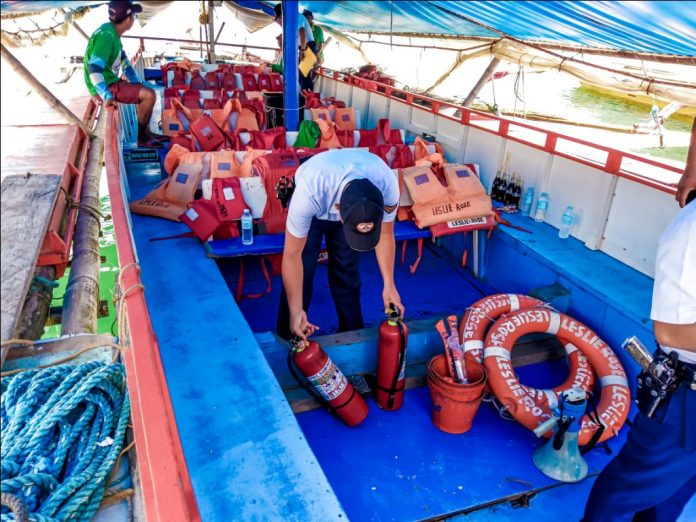 BOAT INSPECTION. A Philippine Coast Guard personnel inspects the safety equipment of this motorboat plying the Iloilo-Guimaras route. Do motorboats crossing the Iloilo Strait have, among others, enough lifejackets for their passengers? IAN PAUL CORDERO/PN