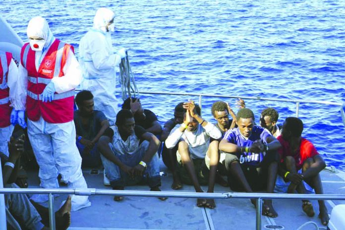 Migrants are evacuated by Italian Coast guards from the Open Arms Spanish humanitarian boat at the coasts of the Sicilian island of Lampedusa, southern Italy, Saturday, Aug. 17, 2019. AP