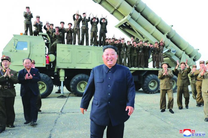 This shows North Korean leader Kim Jong Un, center, smiles after the test firing of an unspecified missile at an undisclosed location in North Korea on Aug. 24, 2019. KOREAN CENTRAL NEWS AGENCY/KOREA NEWS SERVICE VIA AP