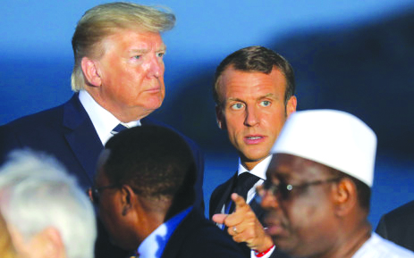 U.S. President Donald Trump (L) and France’s President Emmanuel Macron talk prior to a family picture with G7 leaders and guests, on the second day of the annual G7 summit in Biarritz, south-west France on Aug. 25, 2019. AFP