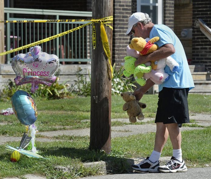 Paul Laughlin, 57, places stuffed animals on Sunday, Aug. 11, 2019 outside a home at 1248 West 11th St. in Erie, Pa., where multiple people died in an early-morning fire. TIMES-NEWS VIA AP