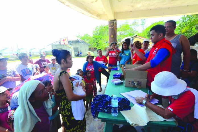 RELIEF OPERATION. Personnel of the Department of Social Welfare and Development distribute relief goods to residents of Barangay Lantangan in Isla Gigantes, Carles, Iloilo on Aug. 10. IAN PAUL CORDERO/PN