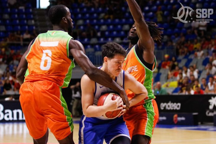 Gilas Pilipinas’ Robert Bolick Jr. tightens his grip on the ball after being trapped by two Ivory Coast defenders. PHOTO COURTESY OF CIGNAL-SBP