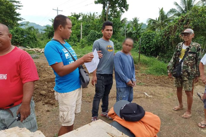 The 43-year-old Ronnie Besona (second from right) was arrested in Barangay Dingginan, Roxas City, Capiz on Thursday for a murder charge. JANIUAY MPS