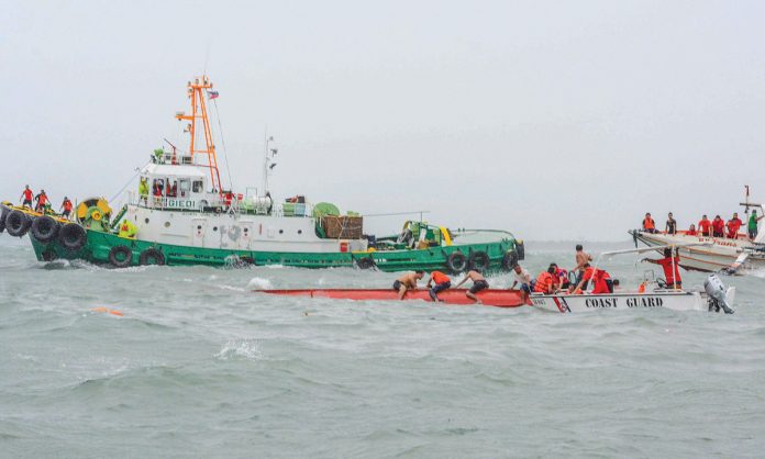 DEADLY SEA MISHAP. Coast guard officials brave the rough waters to search for victims after three motorized boats capsized off Iloilo Strait in separate incidents around noontime yesterday. According to disaster-mitigation authorities, 11 people were confirmed dead. IAN PAUL CORDERO