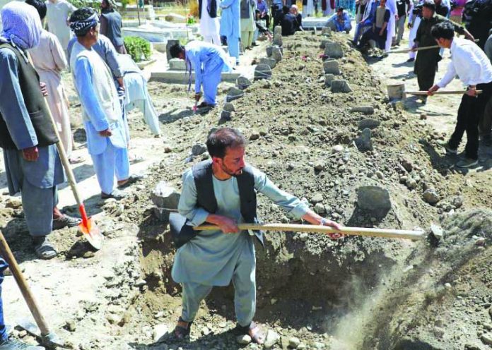 Afghan men dig grave during a mass funeral after a suicide bomb blast at a wedding in Kabul, Afghanistan Aug. 18, 2019. REUTERS