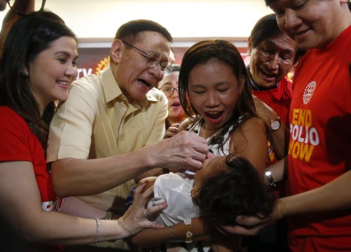 Health secretary Francisco Duque III (second from left) administers anti-polio vaccine to a child in Quezon City on Sept. 20 in a campaign to end the resurgence of the deadly disease. BULILIT MARQUEZ/AP/TIME.COM