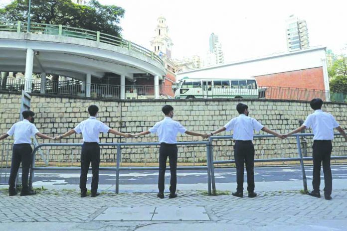 Students hold hands to surround St. Paul's College in Hong Kong, Monday, Sept. 9, 2019. AP