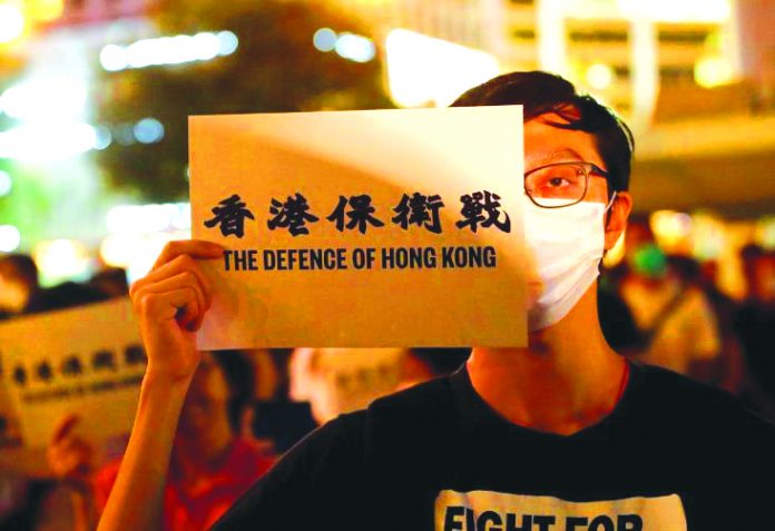 A man covers his eye with a placard as he attends a protest in Hong Kong, China on Aug. 30, 2019. REUTERS