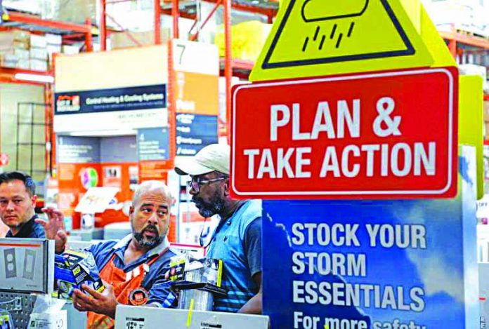 A worker at Home Depot helps customers with storm supplies as people rushed to stock up on necessities ahead of the arrival of Hurricane Dorian in Kissimmee, Florida, U.S. Aug. 30, 2019.