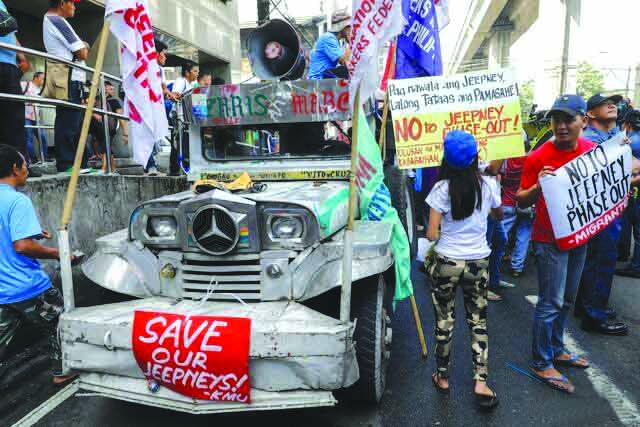 Demonstrators hold signs protesting against the government’s plan to phase-out old jeepneys. Transport groups will push through their planned nationwide strike on Monday. UNTV