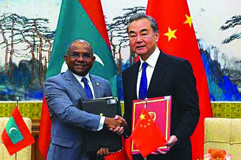 Chinese Foreign Minister Wang Yi and Foreign Minister of Maldives Abdulla Shahid shake hands and hold the signed agreements during the signing ceremony at the end of the meeting at Diaoyutai State Guesthouse, in Beijing, China Sept. 20, 2019. REUTERS