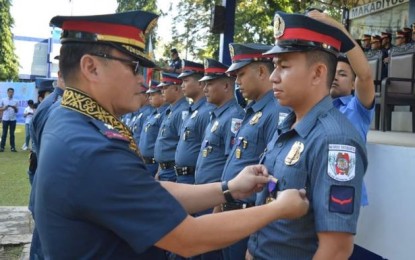 Brigadier General Rene Pamuspusan, director of Police Regional Office 6, pins the Medal of Merit on one of the policemen who implemented successful border control and checkpoint operations in Escalante City, Negros Occidental last month. The “Pagkilala” awarding ceremony was held in Bacolod City on Monday. NEGROS OCCIDENTAL POLICE PROVINCIAL OFFICE