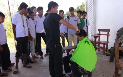 An officer of the Philippine Army gives free haircut to a student in Barangay Tubudan, San Remigio, Antique last year. The Provincial Task Force to End Local Communist Armed Conflict will also conduct a two-day medical and dental mission and information caravan that will benefit around 1,500 individuals from Antique’s two towns starting today. MARGIE GADIAN/PNA