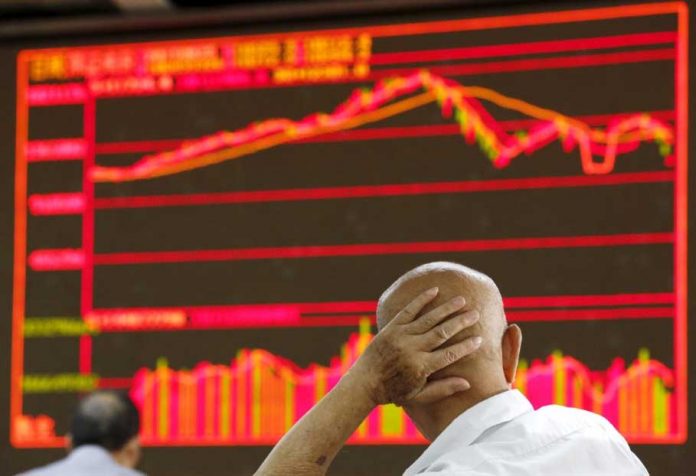 An investor looks at an electronic board showing stock information at a brokerage house in Beijing, China, August 25, 2015. Asian shares and United States stock futures dipped on Wednesday after British lawmakers rejected the government’s timetable to fast-track legislation for its deal to take Britain out of the European Union. KIM KYUNG-HOON/REUTERS