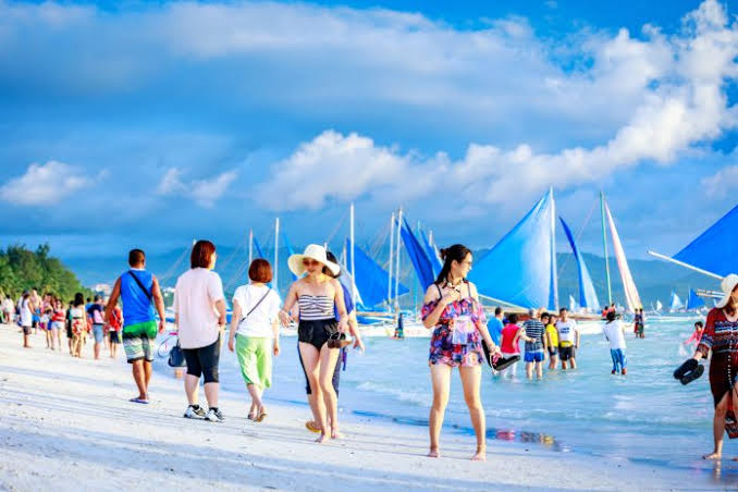 Tourists enjoy the world-famous white sand beach of Boracay Island in Malay, Aklan. Recently, the Department of Trade and Industry here urged tourists to support the “green products” of the island. SHUTTERSTOCK