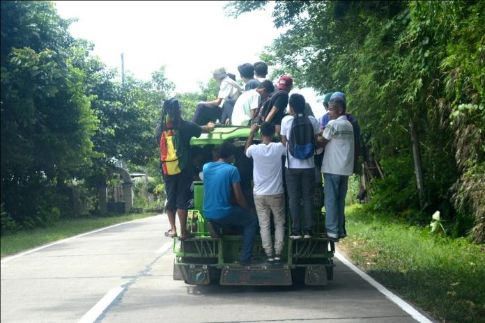 RISKY RIDE. The law is crystal clear: No person shall hang on to, or ride on, the outside or the rear end of any vehicle, and no person on a bicycle, roller skate or other similar device, shall hold fast to or hitch on to any moving vehicle. Also, no driver shall knowingly permit anyone to hitch on to or ride the outside or rear end of his vehicle. Violators face a still fine of at least P6,000, according to the Land Transportation Office. Photo shows an overloaded New Lucena, Iloilo public utility jeepney in Barangay Cabilauan, New Lucena, Iloilo. IAN PAUL CORDERO