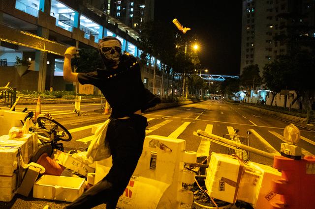 An anti-government protester throws a cocktail toward police officers during a protest at Tseung Kwan O district in Hong Kong, China on Oct. 13. REUTERS/ATHIT PERAWONGMETHA