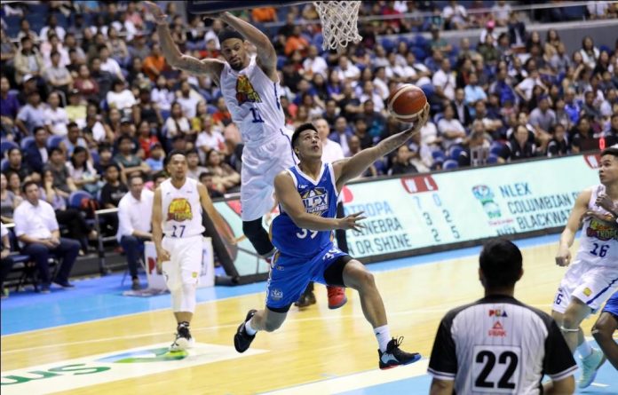 Ilonggo Jericho Cruz of NLEX Road Warriors evades the defense of TNT KaTropa’s KJ McDaniels for a reverse layup. PBA PHOTO