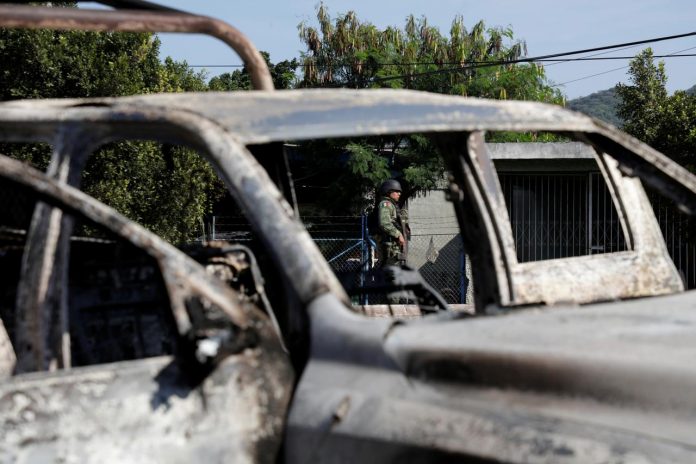 A soldier is seen near the burnt wreckage of a patrol car after an ambush by suspected cartel on police officers in El Aguaje, Michoacan state, Mexico on Oct. 14. REUTERS/ALAN ORTEGA