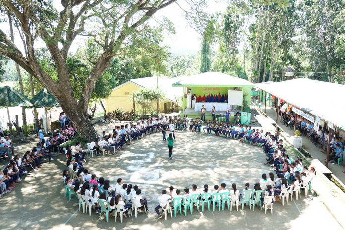 Students and teachers of Barasanan National High School watch a prepared drama skit of the “Dalaw-Turo” team in Tobias Fornier, Antique last week. DENR-6