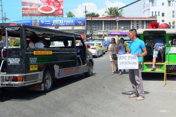 BUSINESS AS USUAL. An Iloilo City passenger jeepney ignores a protester seeking support to Monday’s (Sept. 30, 2019) one-day nationwide transport strike. The Iloilo City government says it was business as usual in this southern metropolis and the strike was hardly felt. The transport holiday was a protest against the phase out of old jeepneys by July 2020. IAN PAUL CORDERO/PN