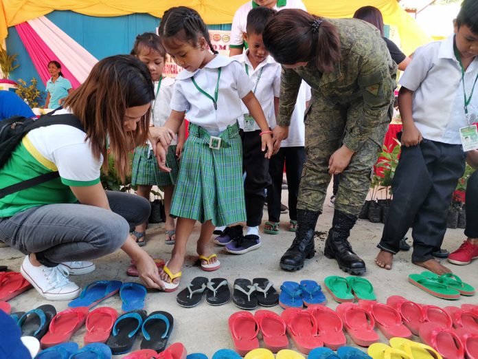 A girl chooses a pair of slippers during the medical and dental information caravan of the Provincial Task Force to End Local Communist Armed Conflict in Barangay Pandanan, Valderrama, Antique. PIA6/T.VILLAVERT