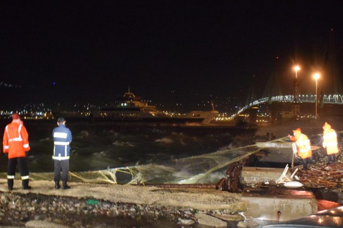 Rescuers stand on a pier as they try to pull up a body using nets after a storm in Antirio, Greece on Nov. 24. REUTERS/VASSILIS DELIMARIS/NO RESALES. NO ARCHIVES