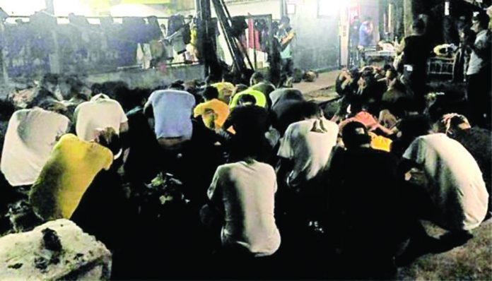 Policemen and soldiers guard the members of progressive groups they rounded up in simultaneous raids on their offices in Bacolod City on the eve of All Saints’ Day. CONTRIBUTED PHOTO