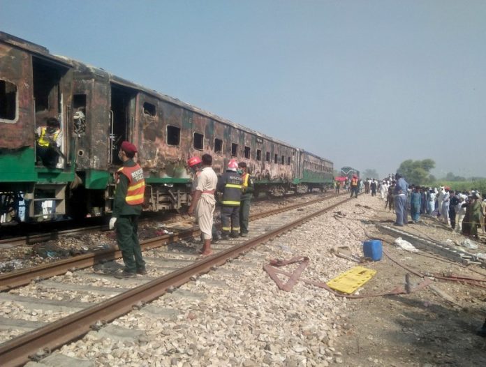 People and rescue workers gather near the site after a fire broke out in a passenger train and destroyed three carriages near the town of Rahim Yar Khan in Pakistan on Oct. 31. REUTERS/STRINGER